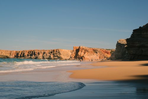 Free Breathtaking view of Tonel Beach cliffs at sunrise in Sagres, Portugal, with golden sands and serene waves. Stock Photo