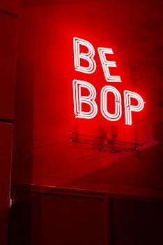 Bright red neon 'Be Bop' sign in Buenos Aires bar, creating a vibrant nightlife atmosphere.