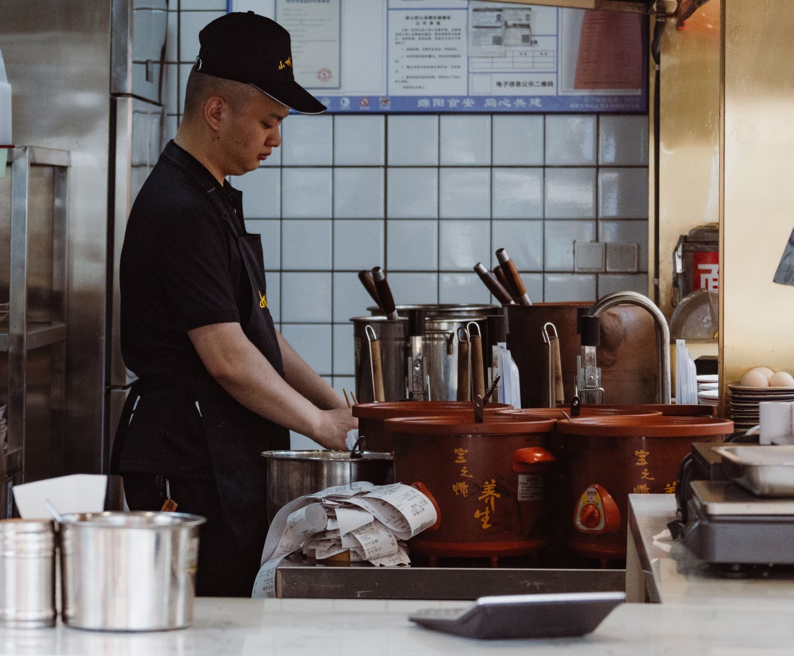 Chef working in an authentic Chinese kitchen with traditional cooking tools and utensils.
