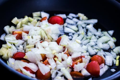 Gratis Tomat Dan Bawang Putih Dimasak Di Wajan Hitam Foto Stok