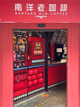 A cozy Nanyang Old Coffee shop with vibrant red decor invites patrons inside.