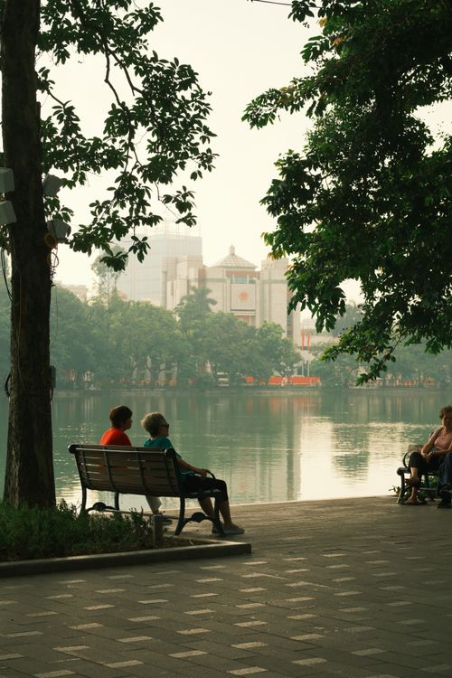 Free Two people sitting by a riverside park in Peru, enjoying a peaceful day. Stock Photo