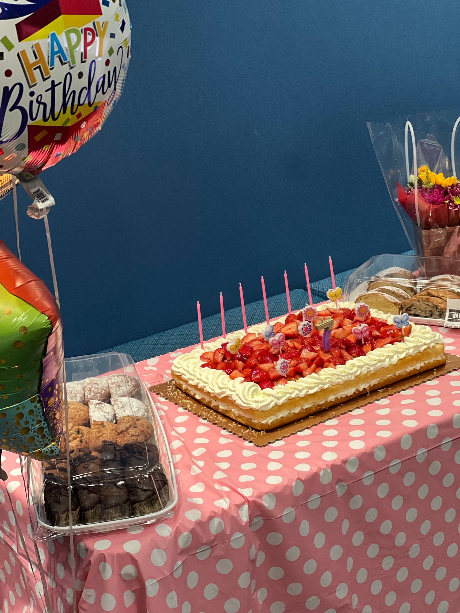 Bright birthday celebration table with balloons, cake, candles and coordinated party decorations