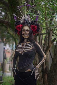 Artfully painted skeleton figure in costume, outdoors with creative crown.