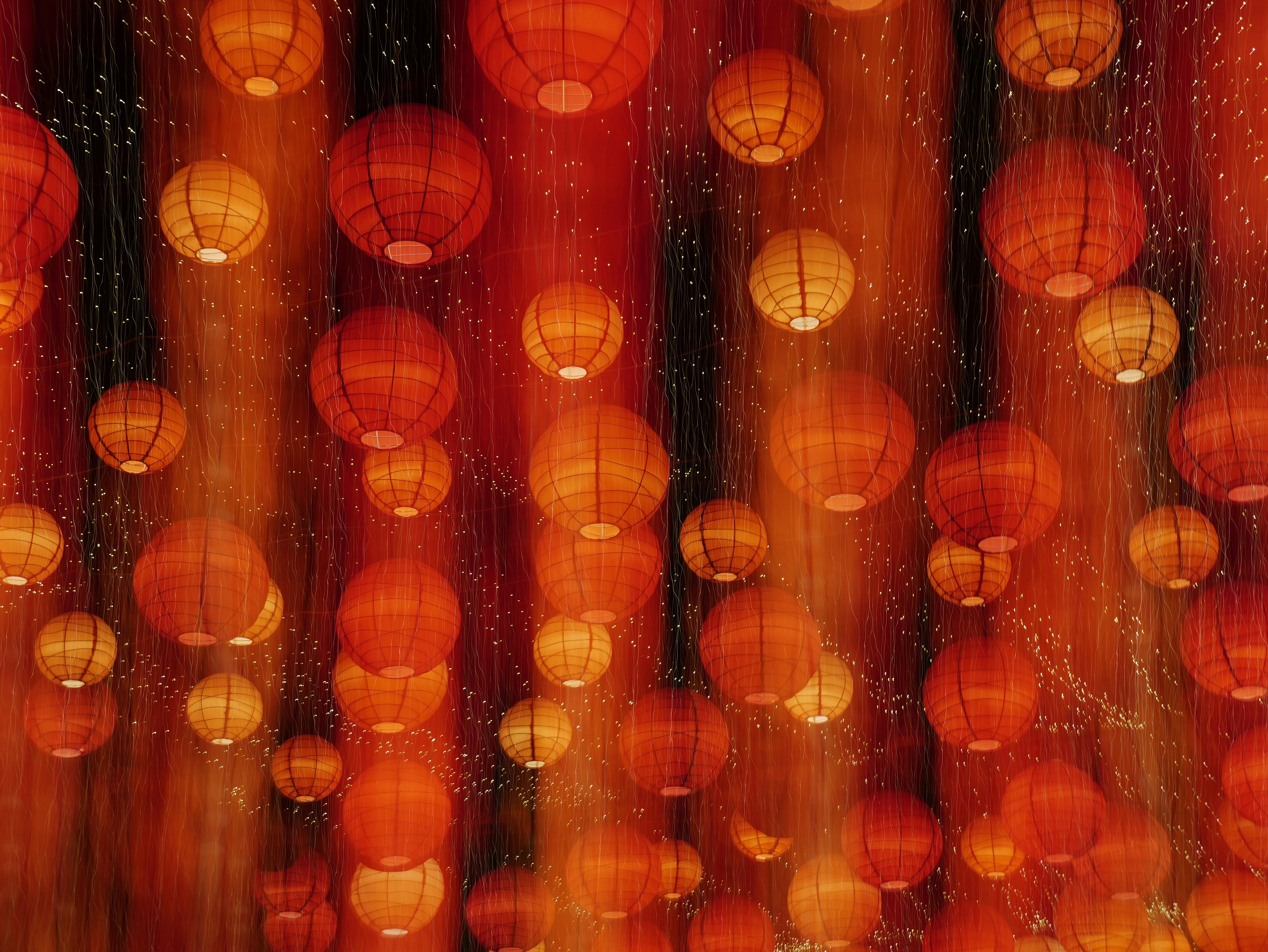 Bright red lanterns create a warm glow at a festive nighttime celebration.