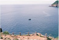 在晴朗的天空下，宁静的海洋上漂浮着一艘孤独的船