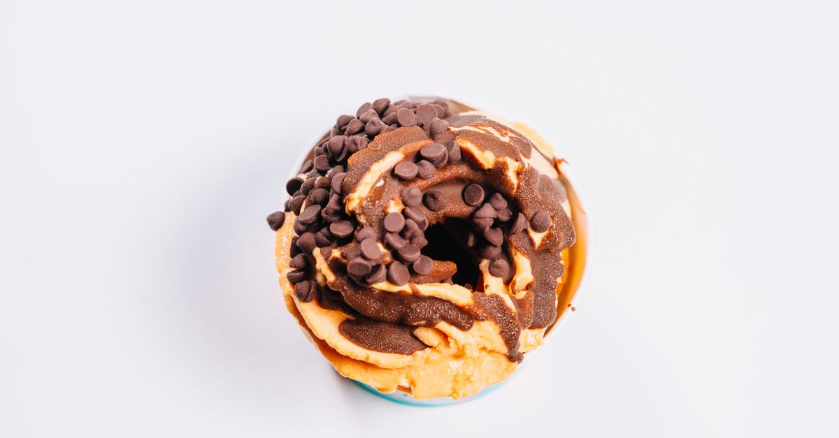 Fluffy baked oats in a small ramekin with chocolate chips and a drizzle of peanut butter