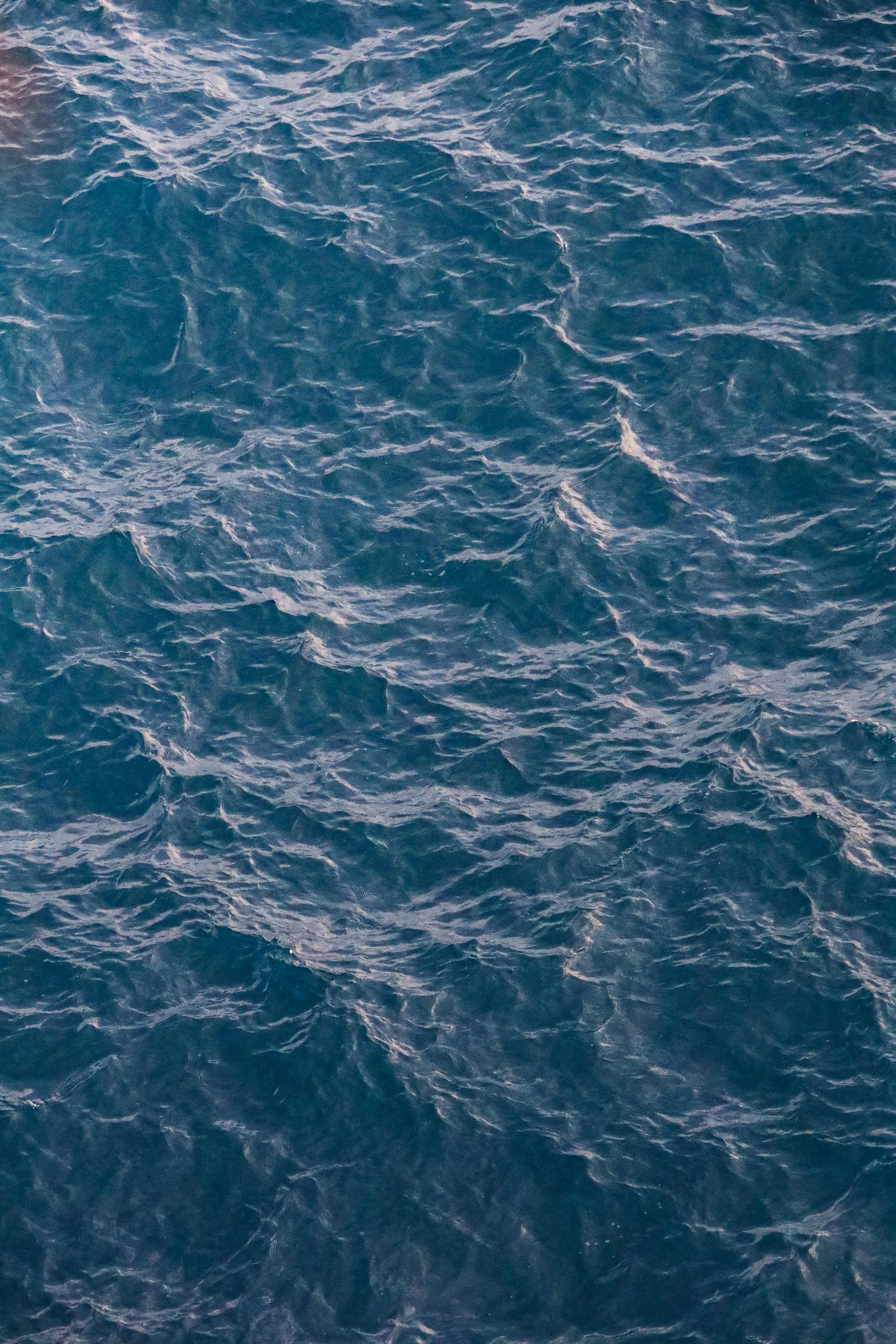 宁静的环境中，美丽的海浪航拍镜头展示了深蓝色的大海