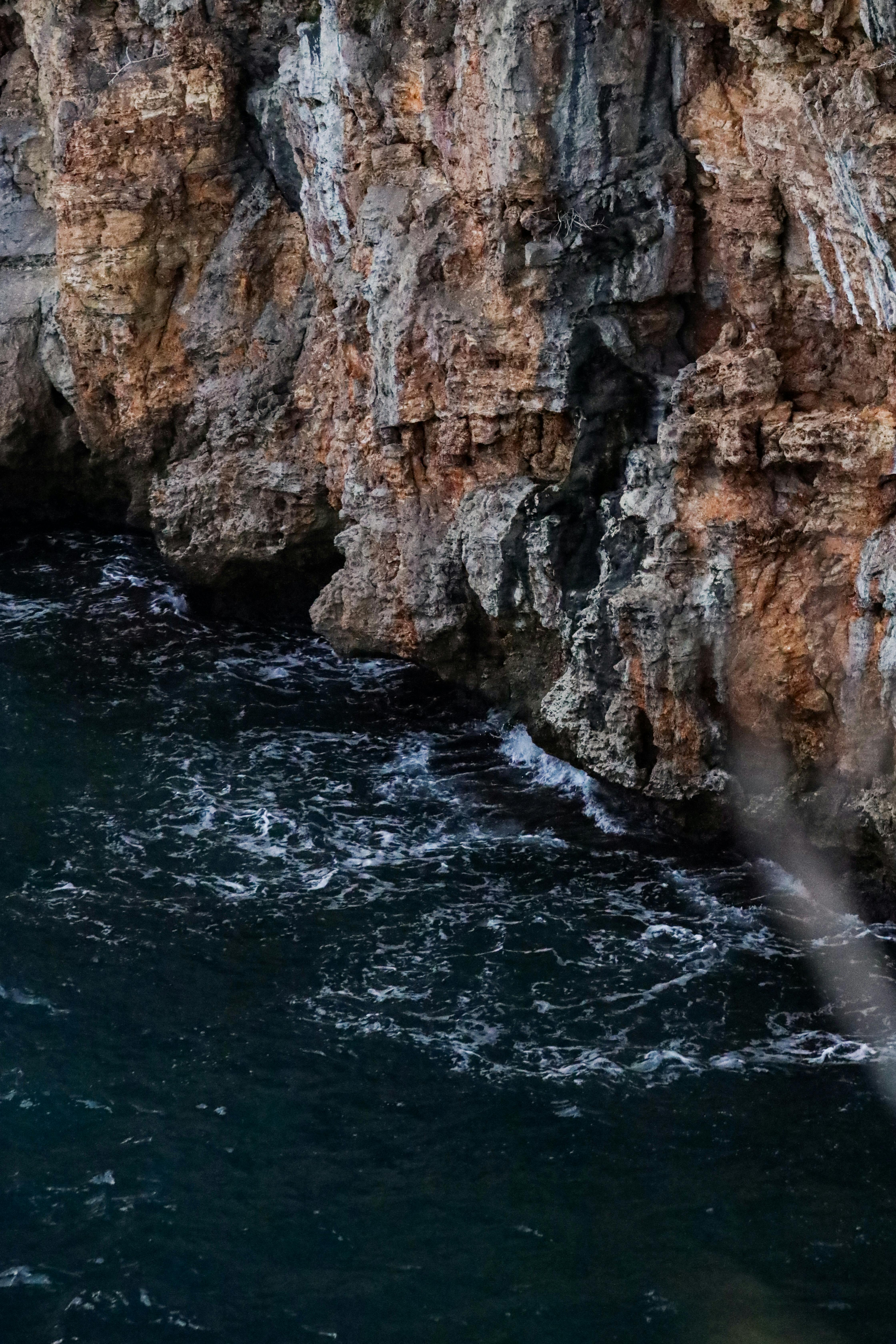 海浪拍打着崎岖的岩石悬崖，捕捉着大自然的原始力量