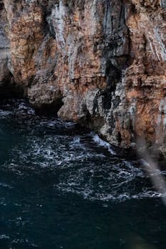 海浪拍打着崎岖的岩石悬崖，捕捉着大自然的原始力量