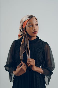 一位身穿黑色连衣裙、戴头巾的女性优雅地摆姿势的肖像