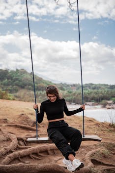 穿着休闲装的年轻女子在风景优美的户外景观中荡来荡去