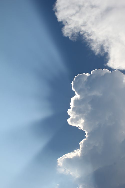 Free Sun Shining Behind Clouds in Blue Sky Stock Photo