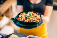 Colorful vegan salad with fresh vegetables served in a restaurant setting.
