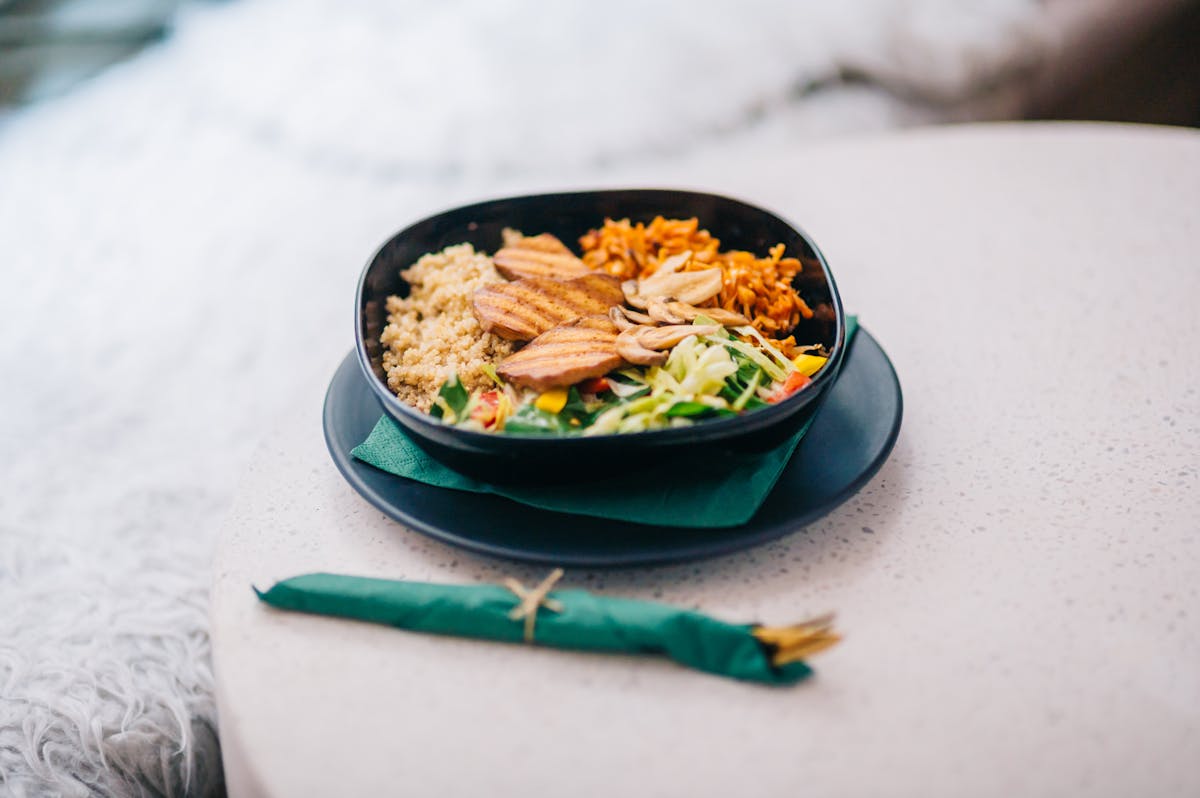 Ciotola vista dall'alto con pollo grigliato, quinoa e verdure