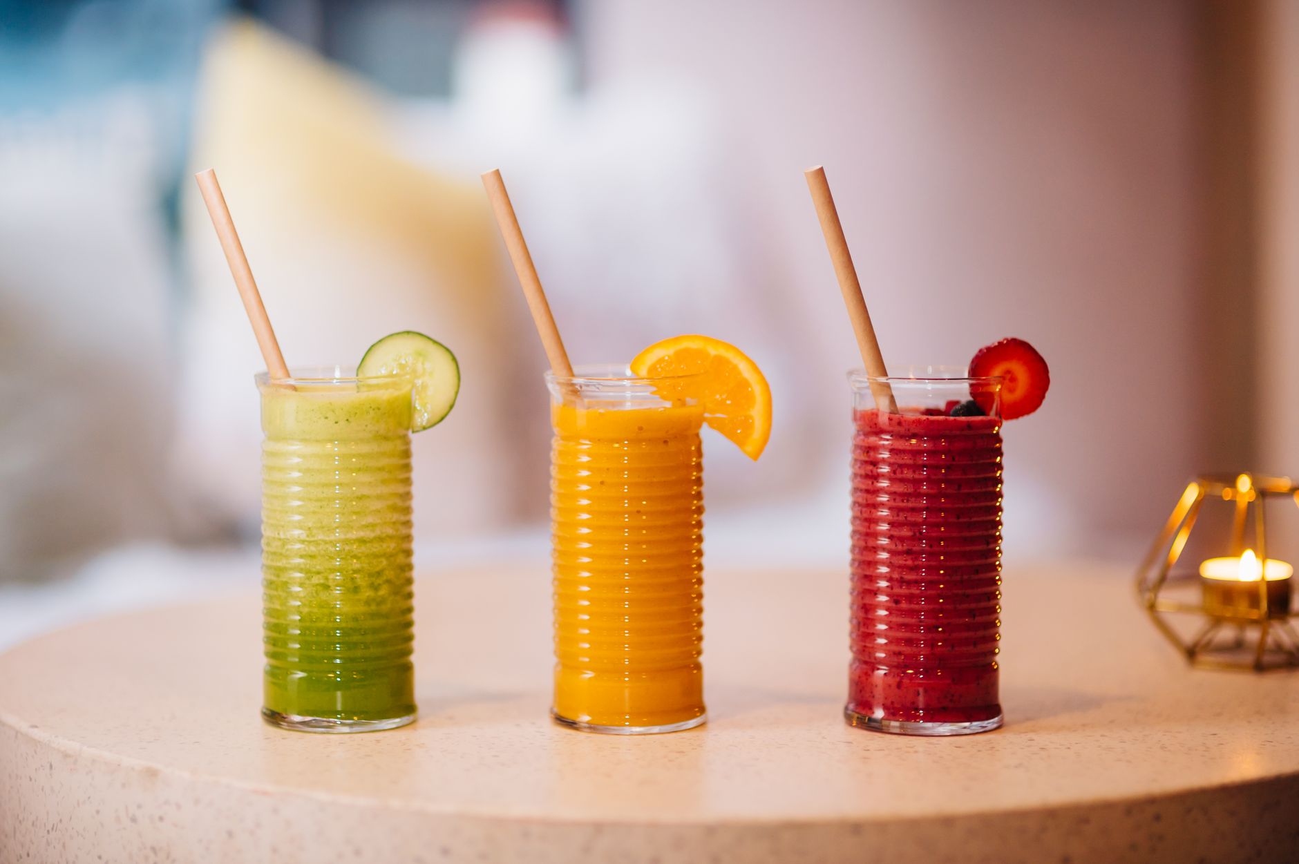 Small glass of bright golden morning juice shot on wooden table
