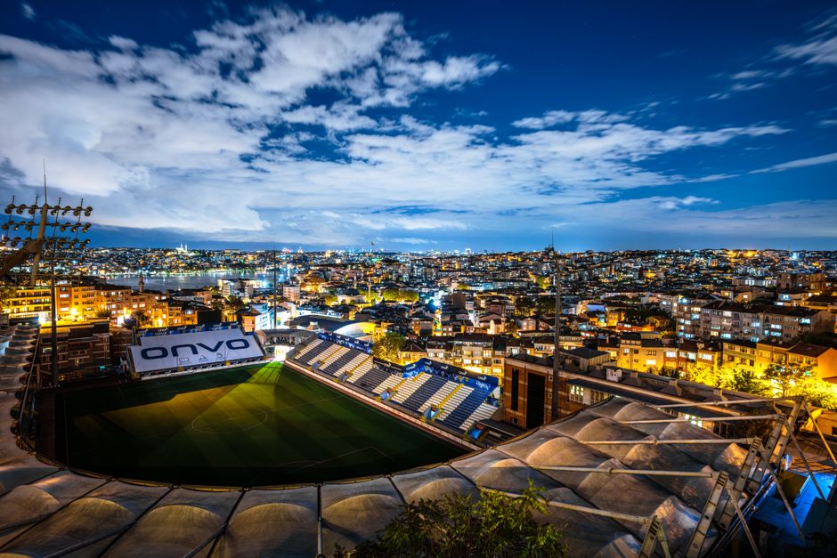 Captivating aerial view of Istanbul city and a stadium illuminated at night under a starry sky. Captivating aerial view of Istanbul city and a stadium illuminated at night under a starry sky.