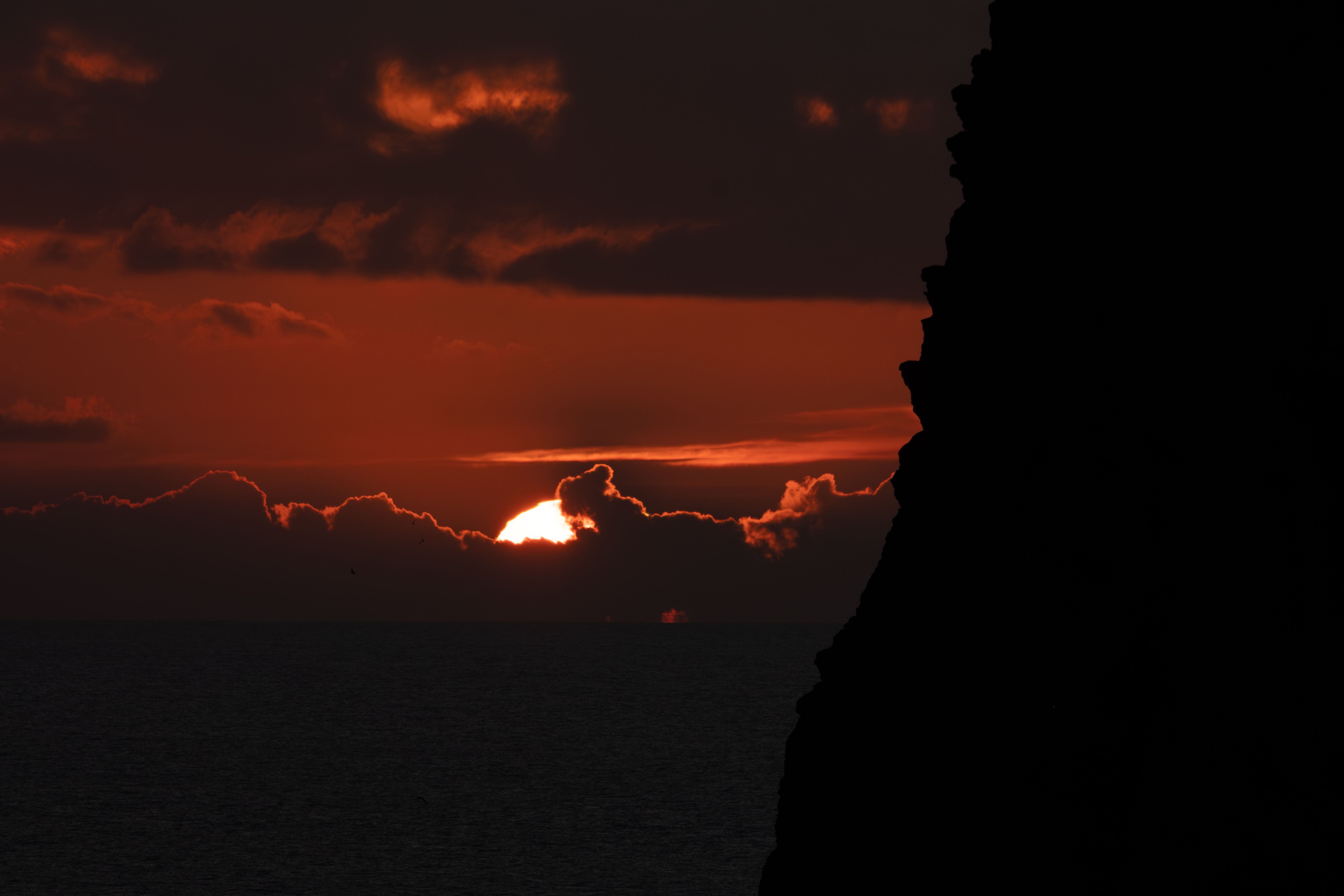 Dramatic Sunset Over Ocean with Cliff Silhouette · Free Stock Photo
