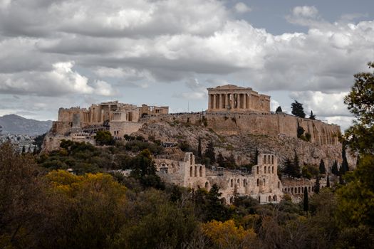 Majestic view of the ancient Acropolis in Athens under dramatic cloudy skies.