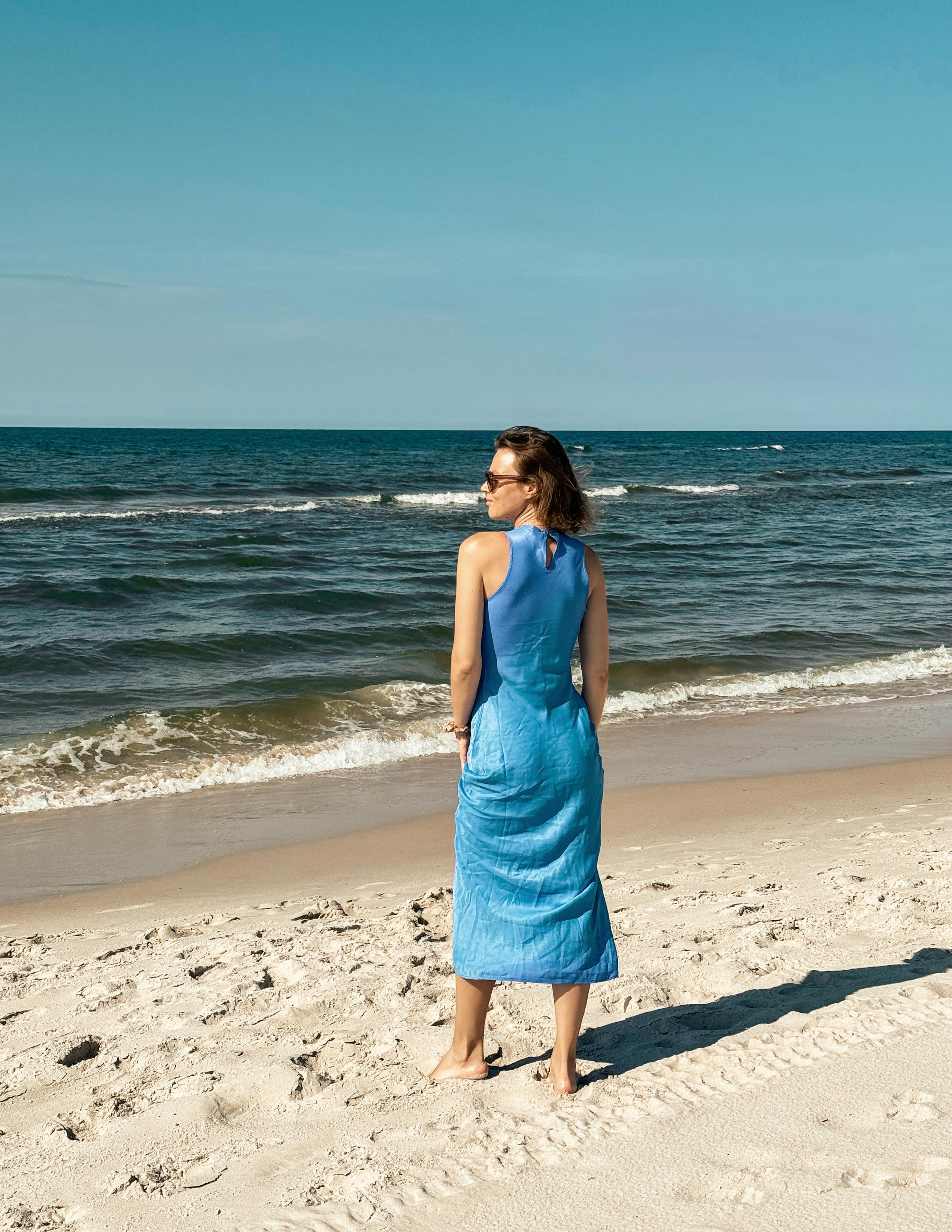 在海边，穿着一件蓝色的绿松石连衣裙