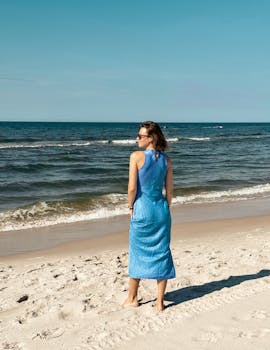 在海边，穿着一件蓝色的绿松石连衣裙