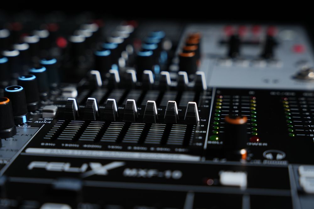 Close-up van de faders en draaiknoppen van een groot mengpaneel