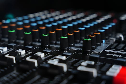Detailed view of a professional audio mixing console with colored knobs.