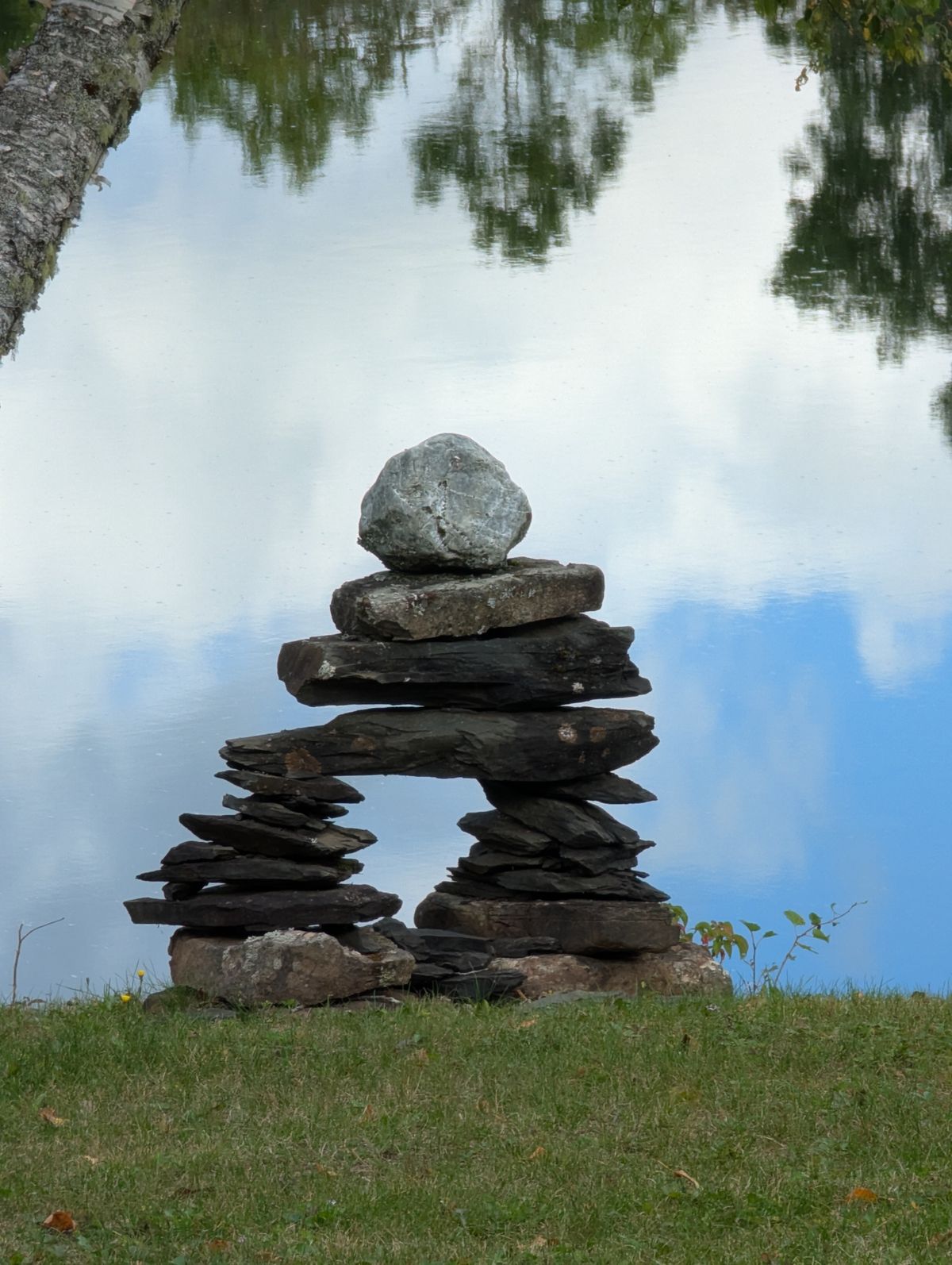 Calm balanced stones by a lake — representing autonomic balance and PEMF as complementary physical support in anxiety