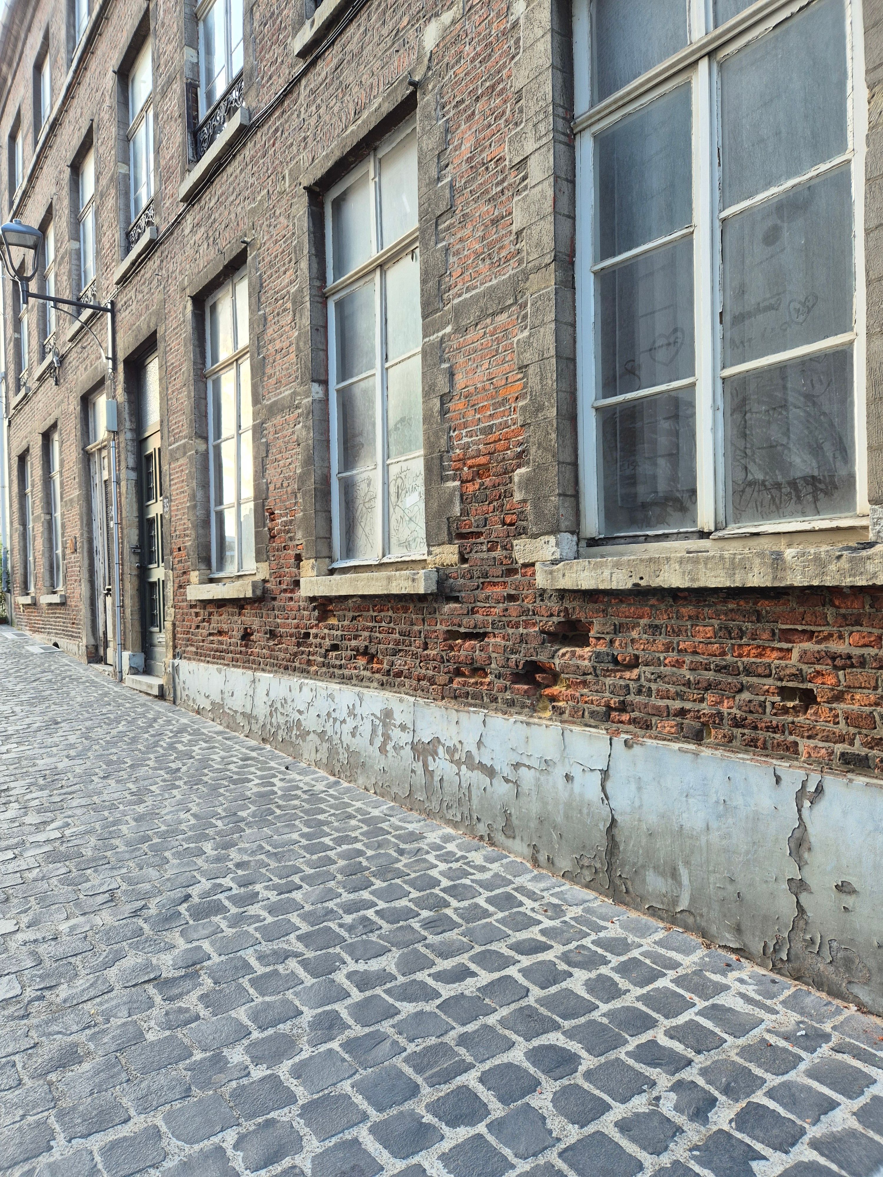 Een tijdloze aanblik van een cobblestone straat omzoomd door historische bakstenen gebouwen, die klassieke charme oproept.