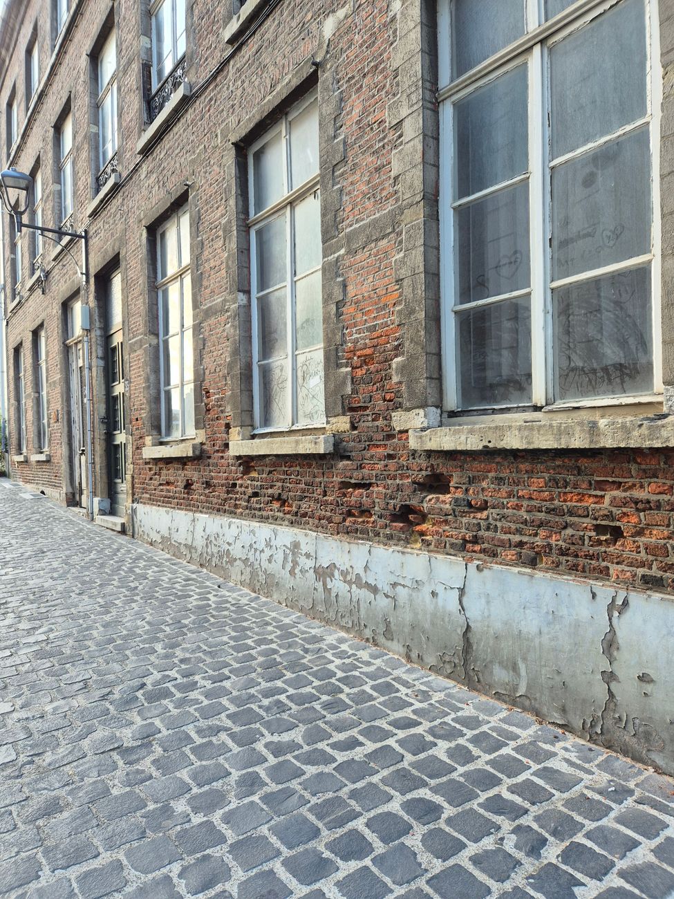 Een tijdloze aanblik van een cobblestone straat omzoomd door historische bakstenen gebouwen, die klassieke charme oproept.