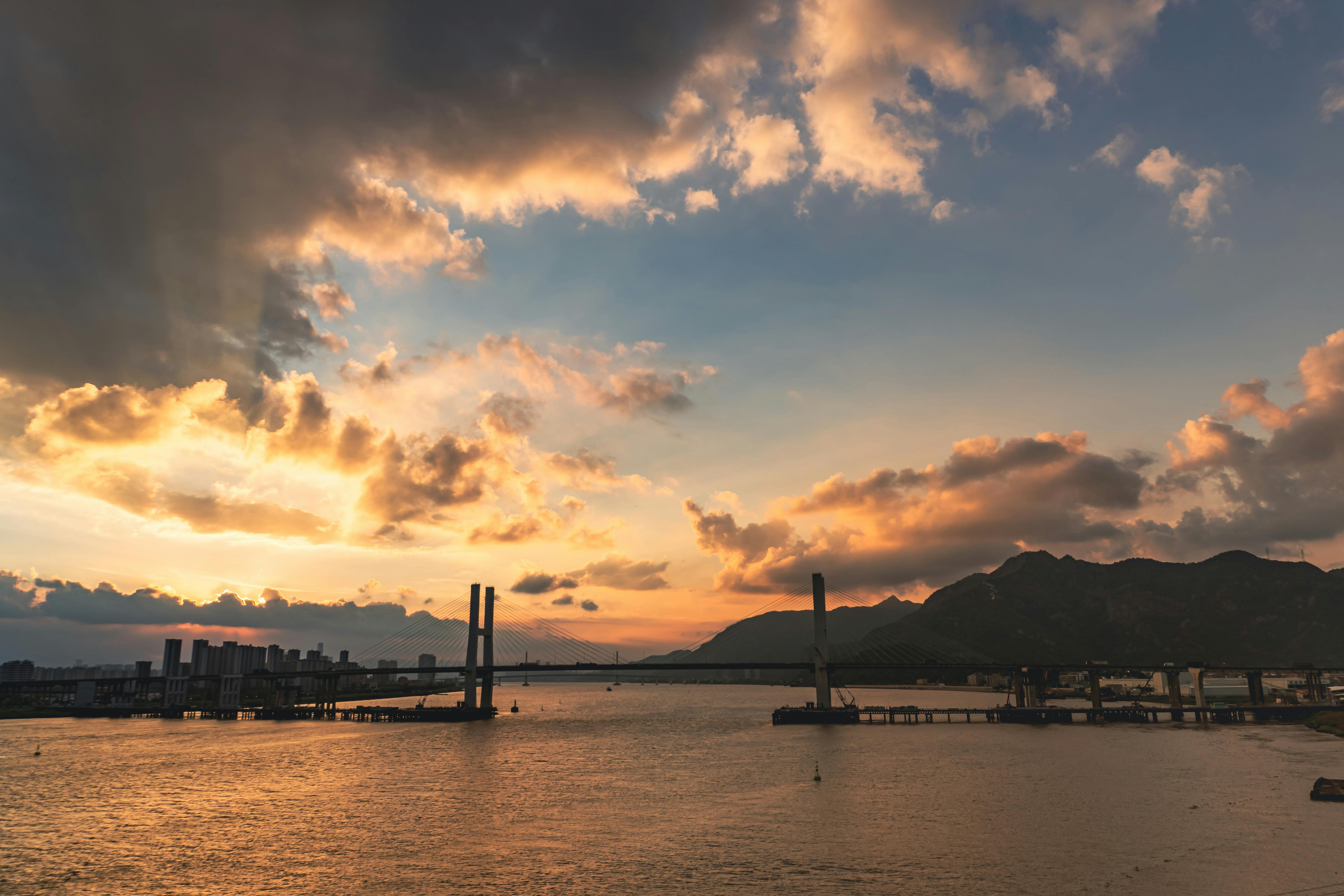Stunning sunset view over a bridge in Wenzhou, capturing vibrant clouds and mountains.