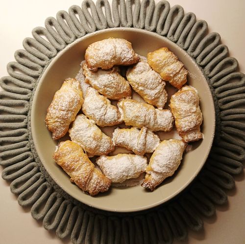Free Plate of flaky, powdered sugar-coated croissants, perfect for enjoying with coffee or tea. Stock Photo