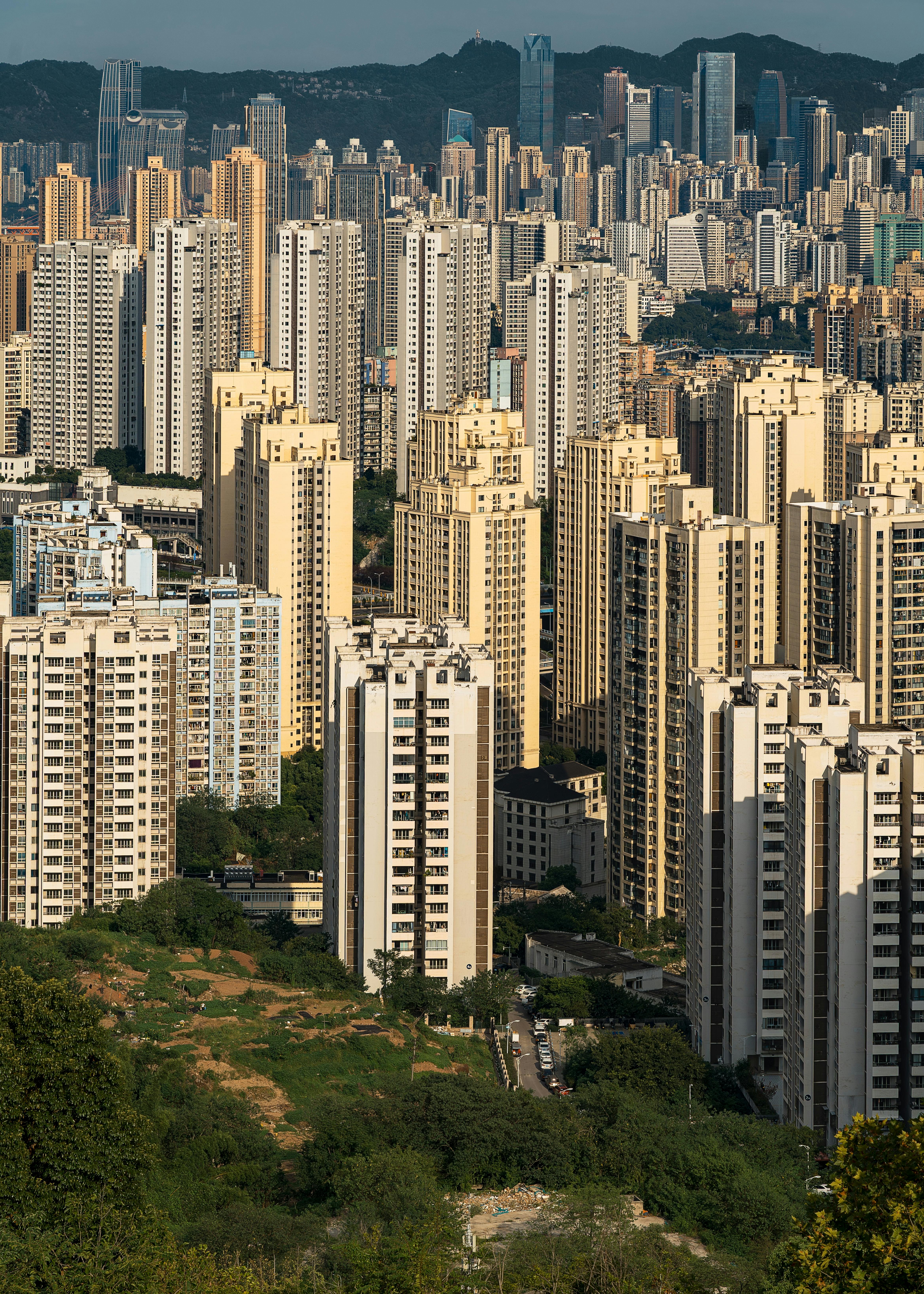 A vibrant aerial cityscape showcasing a densely packed skyline of high-rise buildings under a clear sky.