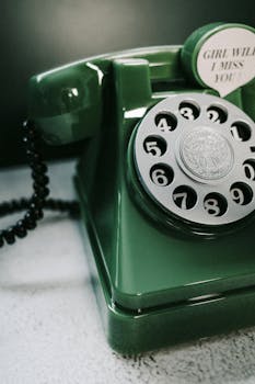 Close-up of a vintage green rotary telephone with a retro aesthetic and sentimental message.