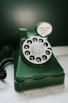 A nostalgic green rotary phone with a speech bubble saying 'Girl will I miss you?'