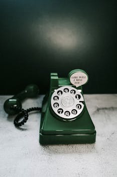 Classic green rotary phone with "Girl will I miss you" text evokes retro nostalgia.