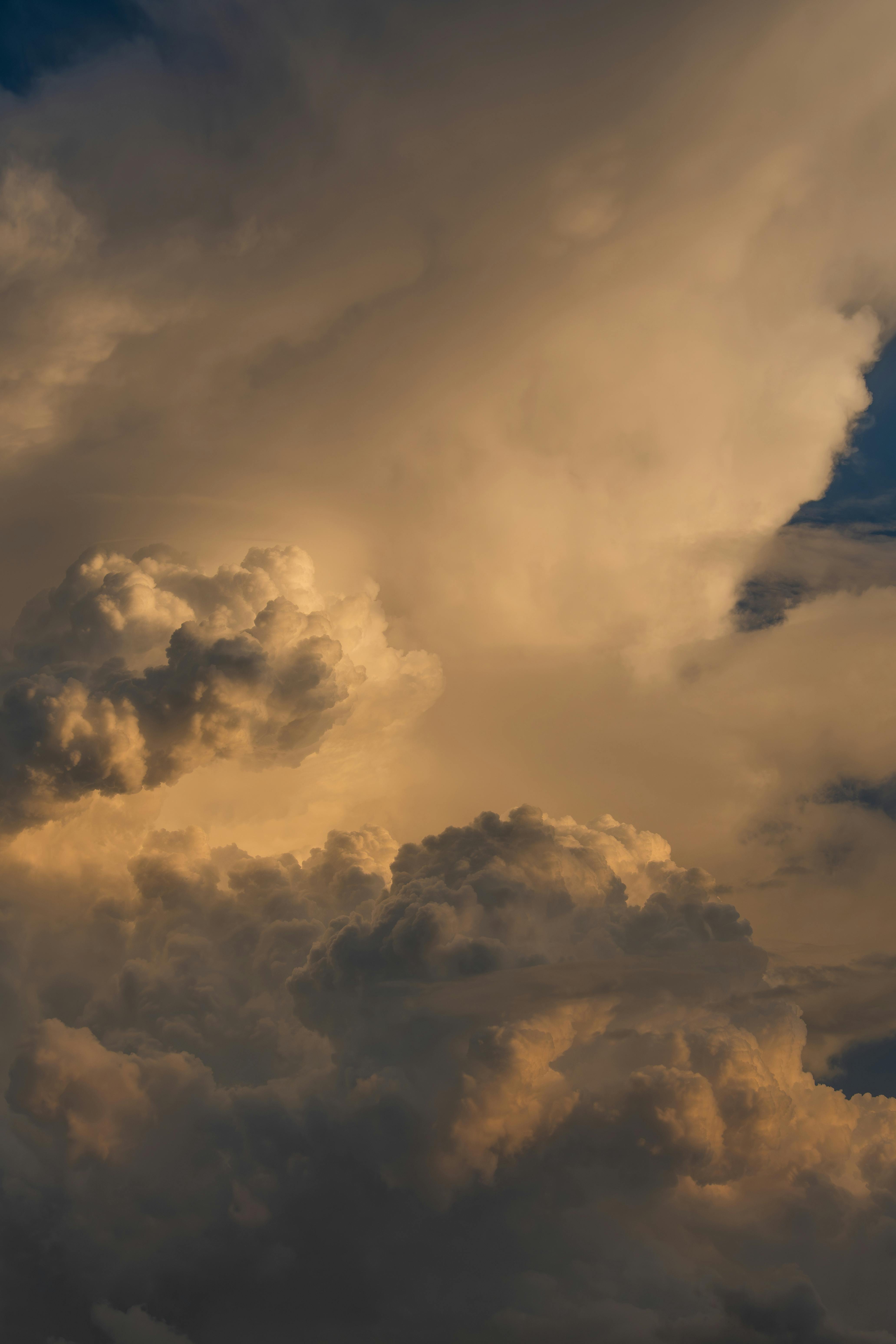 积雨云日落时，天空被厚厚的云层覆盖，阳光透过云缝洒下，形成一道道金色的光柱