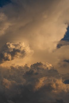积雨云日落时，天空被厚厚的云层覆盖，阳光透过云缝洒下，形成一道道金色的光柱