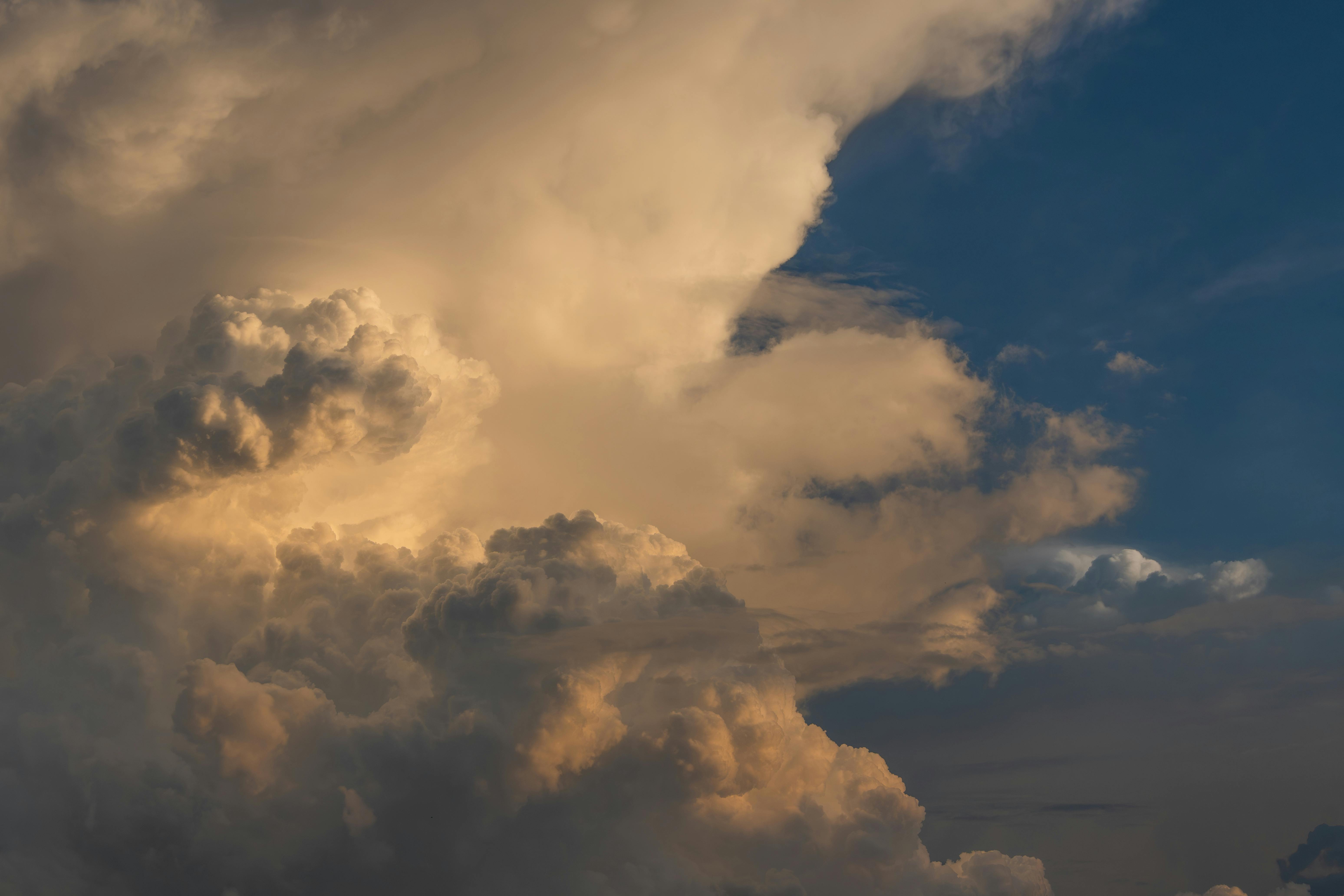 积雨云日落的表达不够通顺，可以优化为：在积雨云的映衬下，夕阳缓缓落下