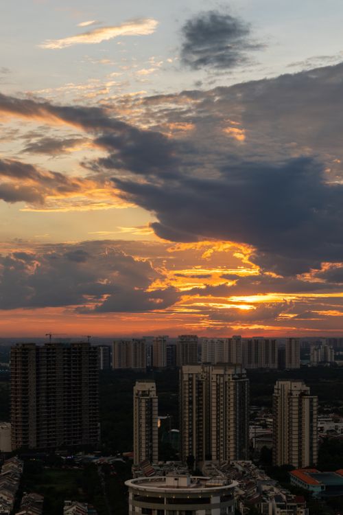 Free Captivating city skyline at sunset with vibrant clouds and high-rise buildings. Stock Photo