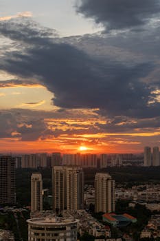 Beautiful sunset over city skyline with skyscrapers and dramatic clouds.