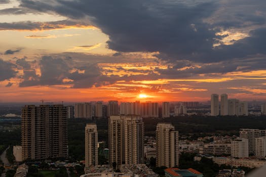 Stunning sunset over a cityscape with tall buildings and dramatic clouds.