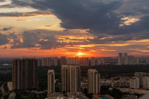 Free Stunning sunset over a cityscape with tall buildings and dramatic clouds. Stock Photo