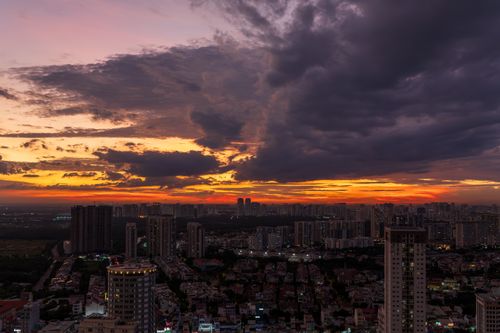 Free A breathtaking city skyline at sunset with dramatic clouds and vibrant colors. Stock Photo