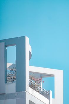 Elegant white architectural structure with minimalist design against a vibrant blue sky.