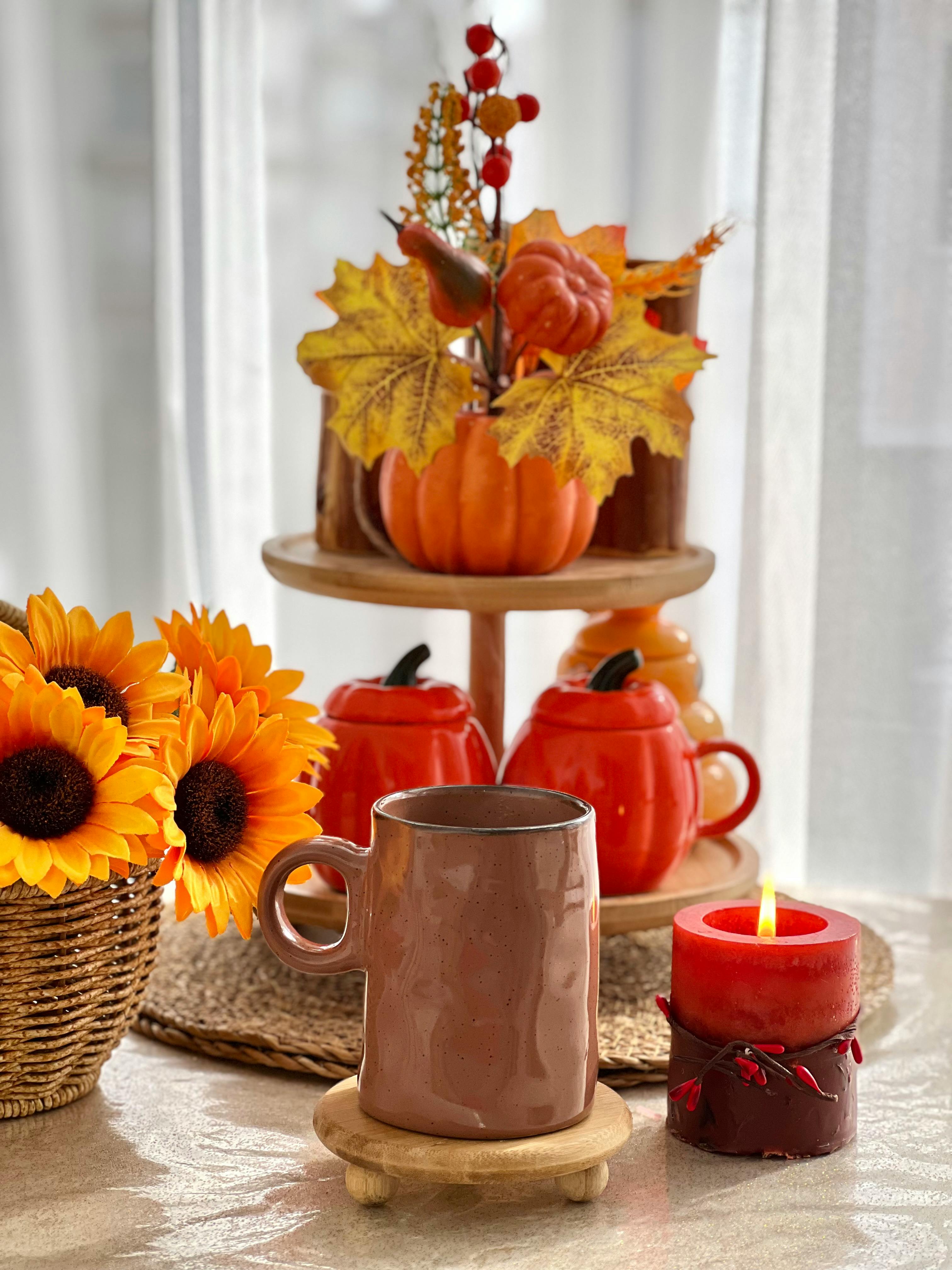 Fall-inspired coffee scene with ceramic mug, sunflowers, and decorative pumpkins.