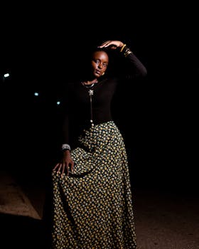 时尚的女人在夜晚的灯光下自信地摆姿势，用花裙子展示优雅的时尚感