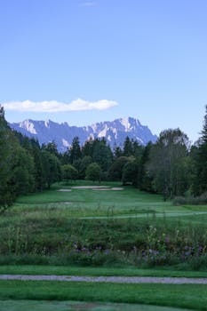 令人惊叹的绿色高尔夫球场的景色，背景是雄伟的山脉