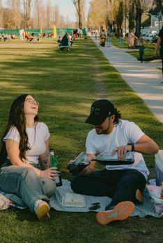 A young couple enjoying a sunny picnic day in a Buenos Aires park.