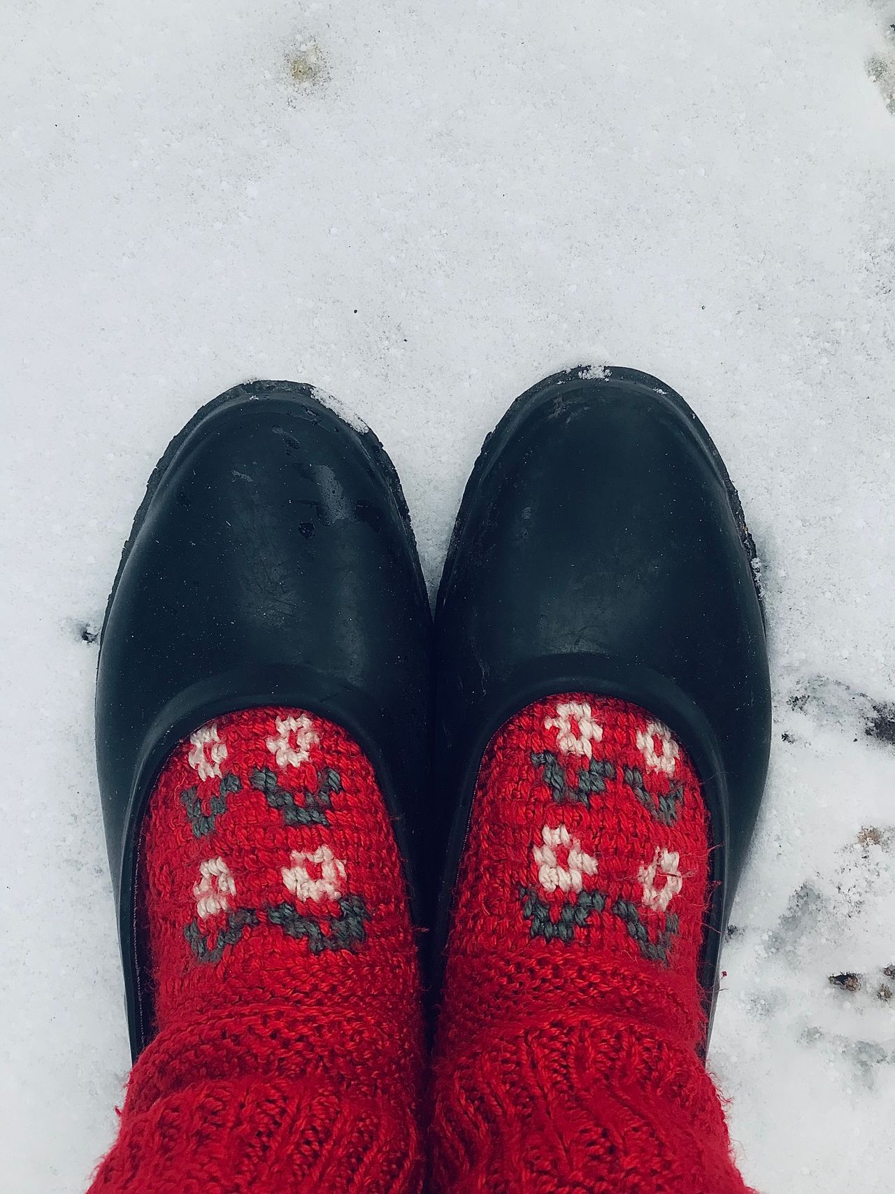 red floral-patterned socks visible above black shoes in snow